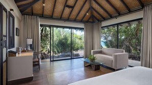 A spacious room with a large bed, a seating area, and a desk. - Ravana Garden (Hambantota)