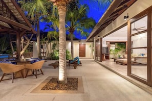 Patio interior con palmera, zona de estar y piscina.