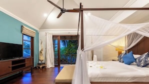 A bedroom with a four-poster bed, a television, and a balcony with a view of greenery. - Aqua Vista 28: 3BR Thai Style Villa (Koh Samui)