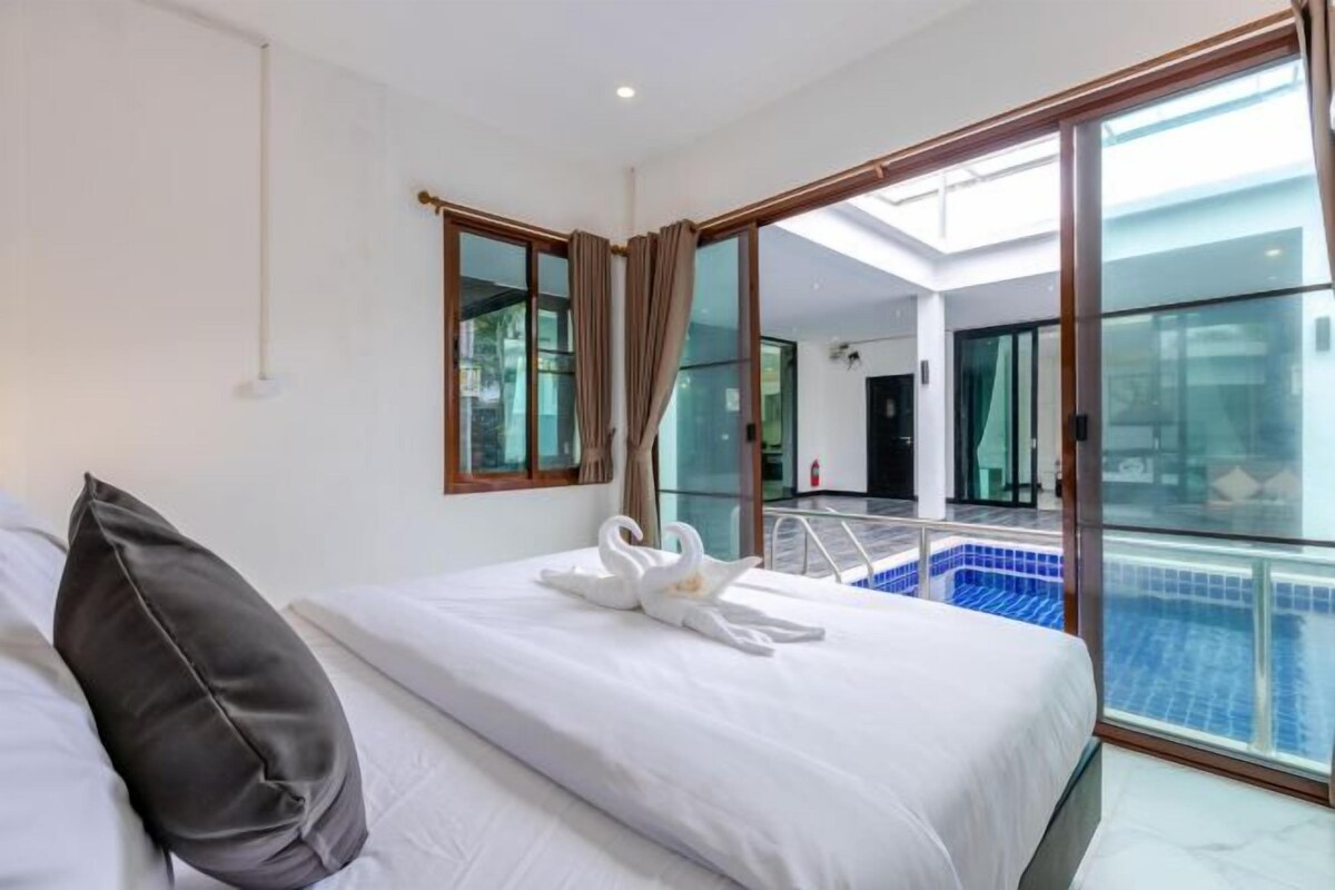 A hotel room with a bed, a window, and a view of a swimming pool.