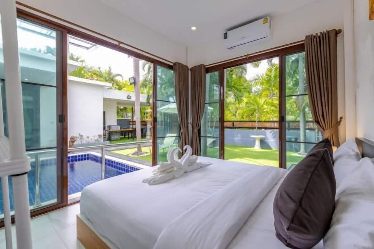 Une chambre d’hôtel avec un grand lit, une vue sur la piscine et un balcon.