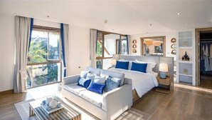 A modern hotel room with a large bed, a sofa, a coffee table, and a wardrobe. - Phuket Royal Marina & Resort 4 bedroom Penthouse (Phuket)