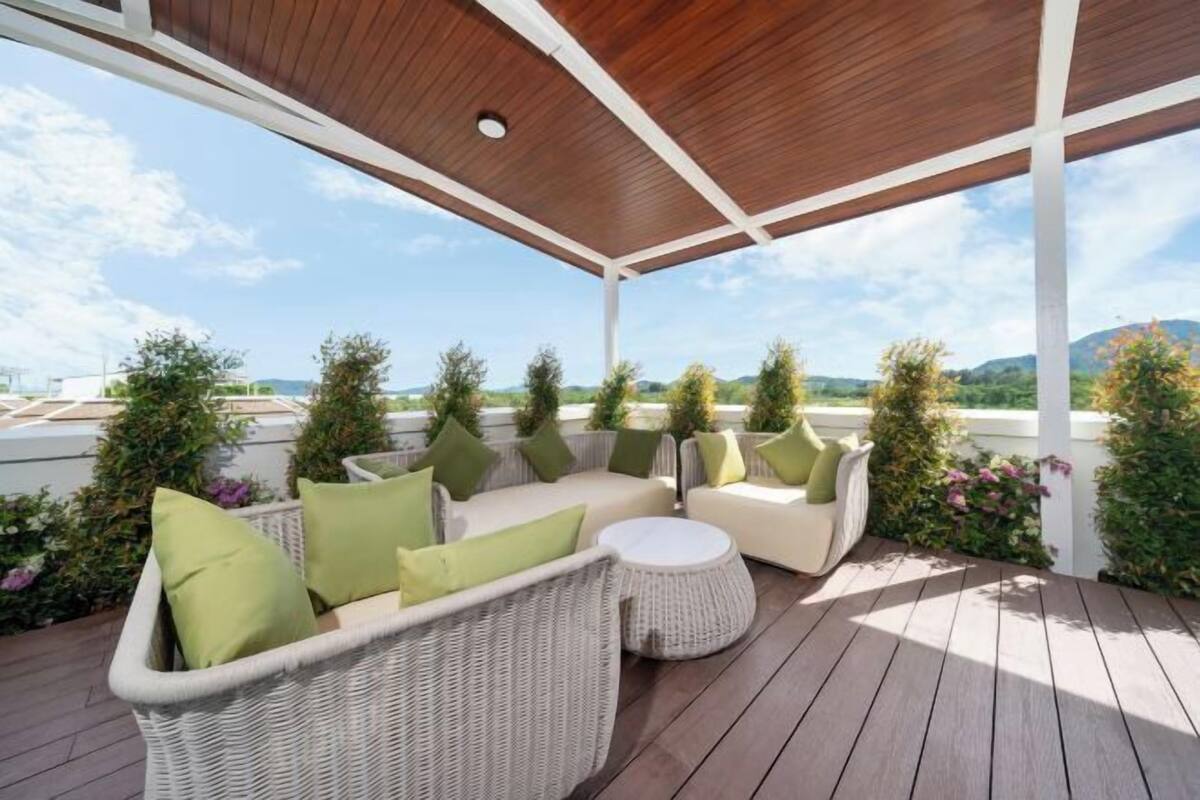 Una terrazza all'aperto con mobili in vimini, un tavolo rotondo e vista sul paesaggio.