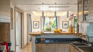 A modern kitchen with a central island, built-in cabinetry, and pendant lighting. - Phuket Royal Marina & Resort 4 bedroom Penthouse (Phuket)