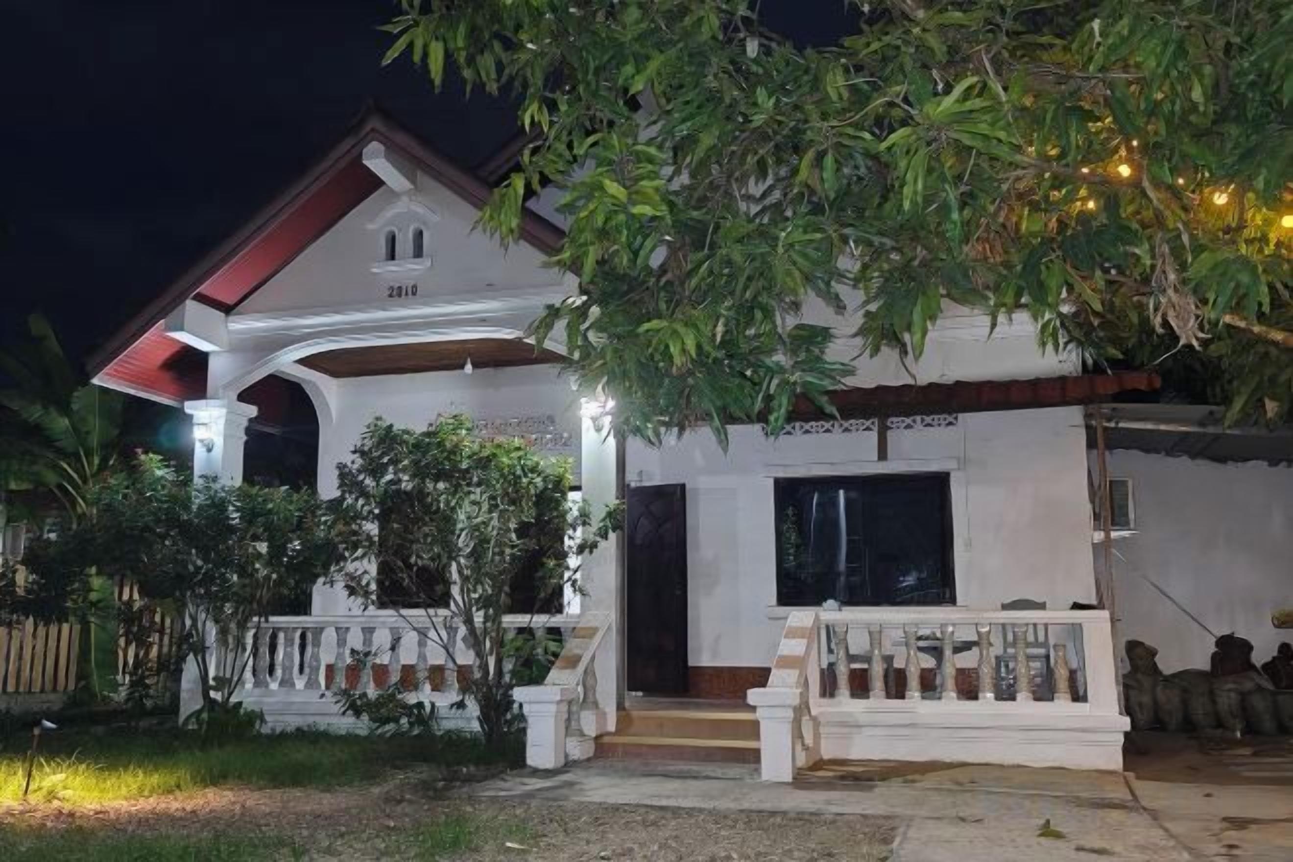 Une maison à deux étages avec un porche, un garage et une entrée bien éclairée.