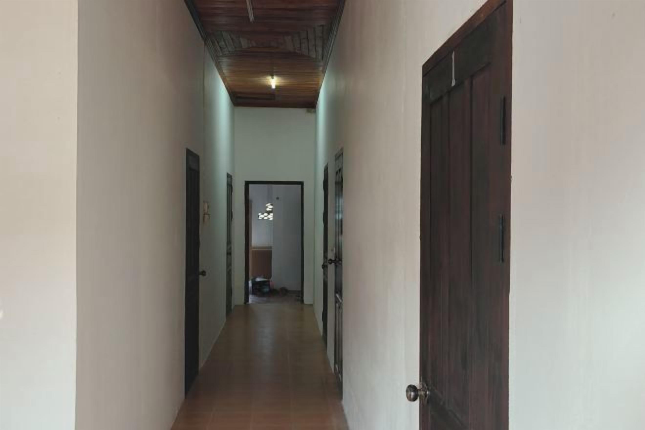 A narrow hallway with a wooden ceiling and a door on the right.