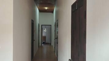 A narrow hallway with a wooden ceiling and a door on the right.