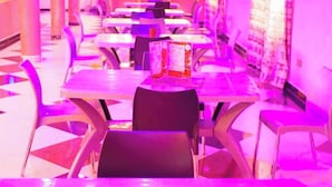 A brightly lit restaurant with tables and chairs arranged for dining. - Baaz Hotel Kakamega (Kakamega)