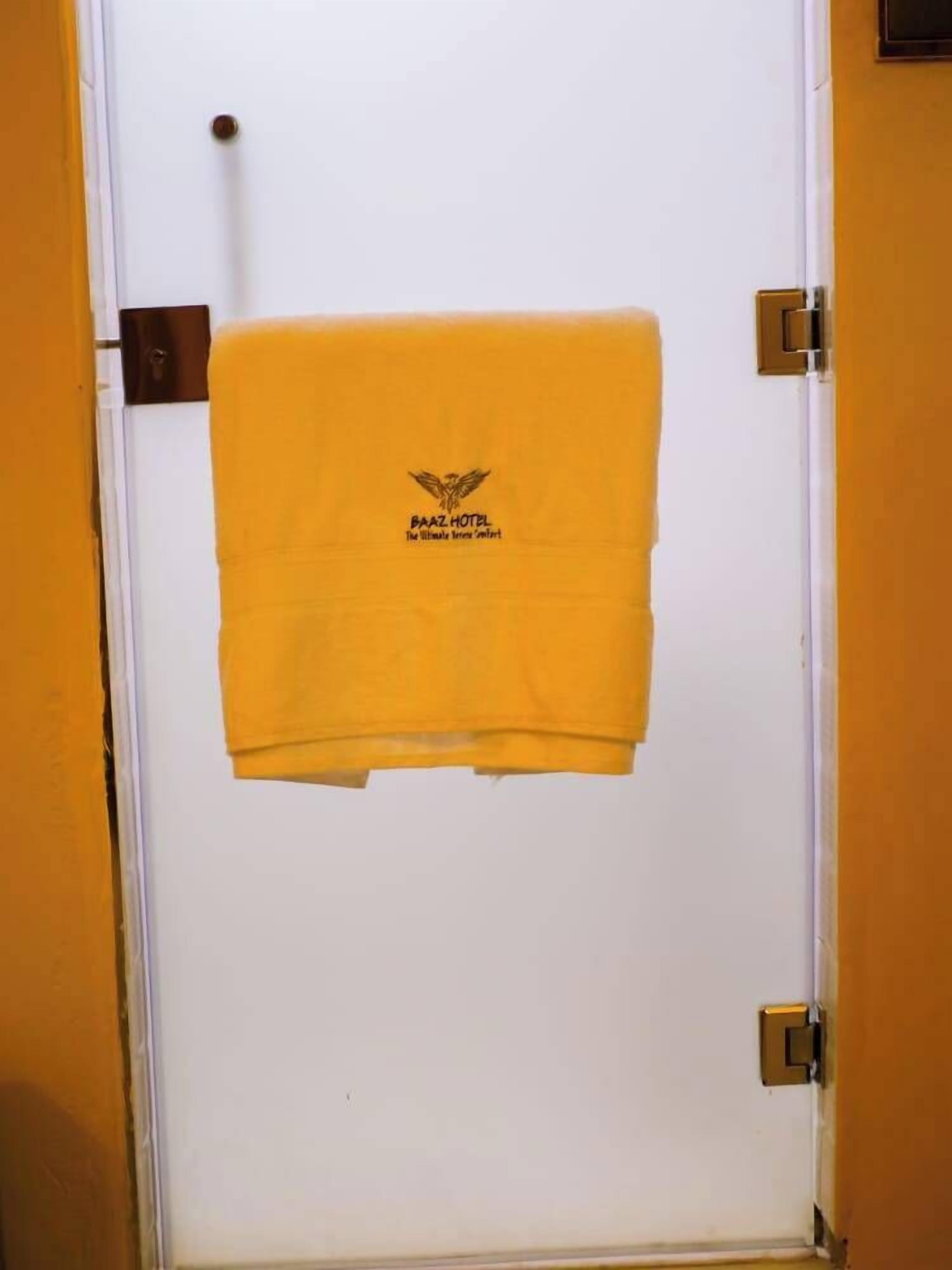 Een deur met een gele handdoek eroverheen, met het logo van Hotel Baaz.
