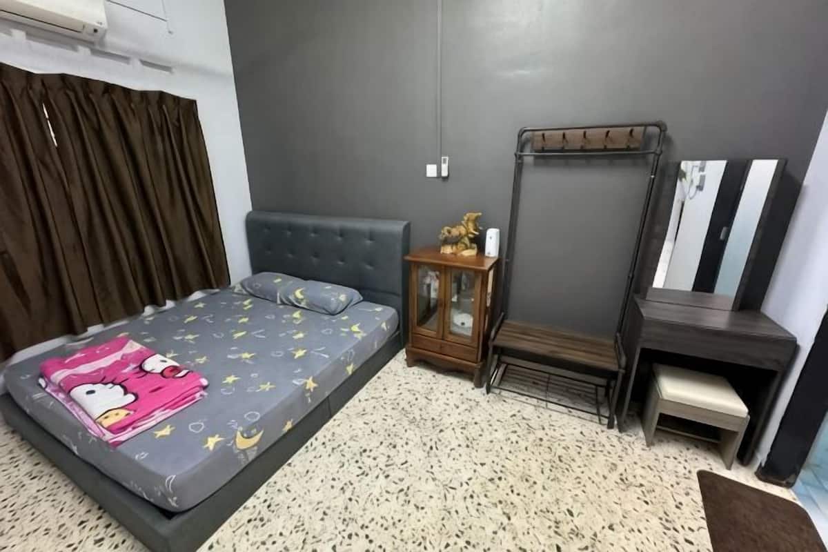 A bedroom with a bed, a nightstand, a dresser, a mirror, and a window with curtains.