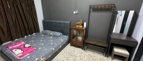 Ein Schlafzimmer mit Bett, Nachttisch, Schminktisch und Spiegel, sowie einem Fenster mit Vorhängen.