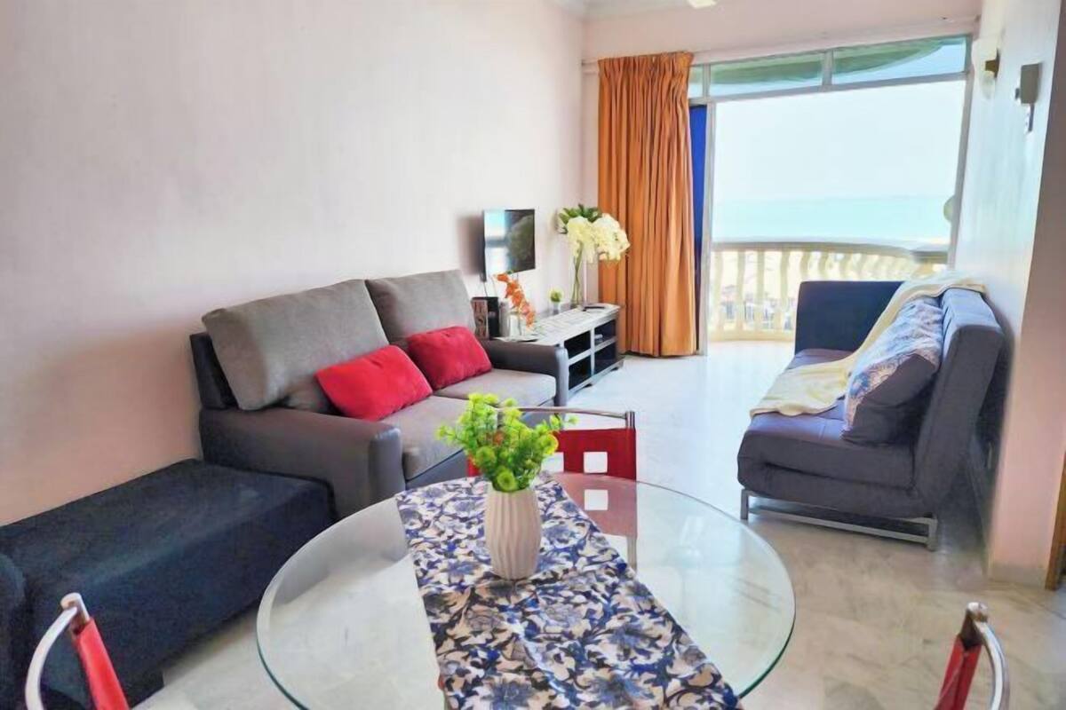 Una sala de estar moderna con un sofá, una mesa de centro de vidrio y un televisor.