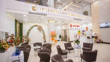 A hotel lobby with a reception desk, seating area, and a Christmas tree.