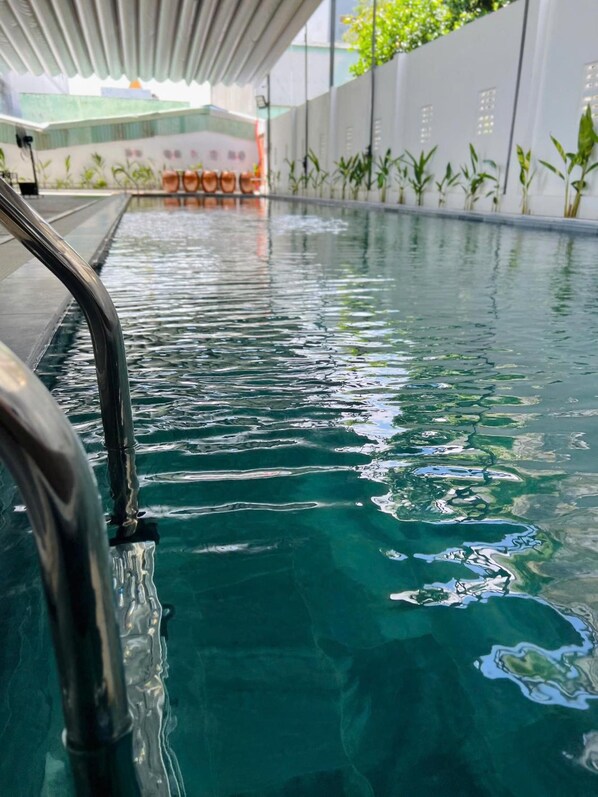 Piscina com água cristalina e guarda-corpo de metal.