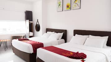 Une chambre d’hôtel avec deux lits, une petite table et des œuvres d’art accrochées au mur.