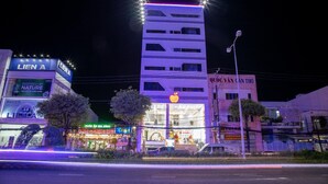 A multi-story building with illuminated signage, including a prominent 'LIEN A' sign. - Apple Hotel (Can Tho)