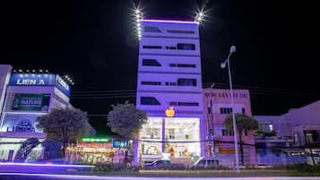 Un immeuble à plusieurs étages doté d’une enseigne lumineuse, notamment d’une grande enseigne « LIEN A ».