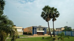 A building labeled "City Hall" with a central entrance, surrounded by a well-maintained lawn and palm trees. - Celebration Park (Gobindpur)