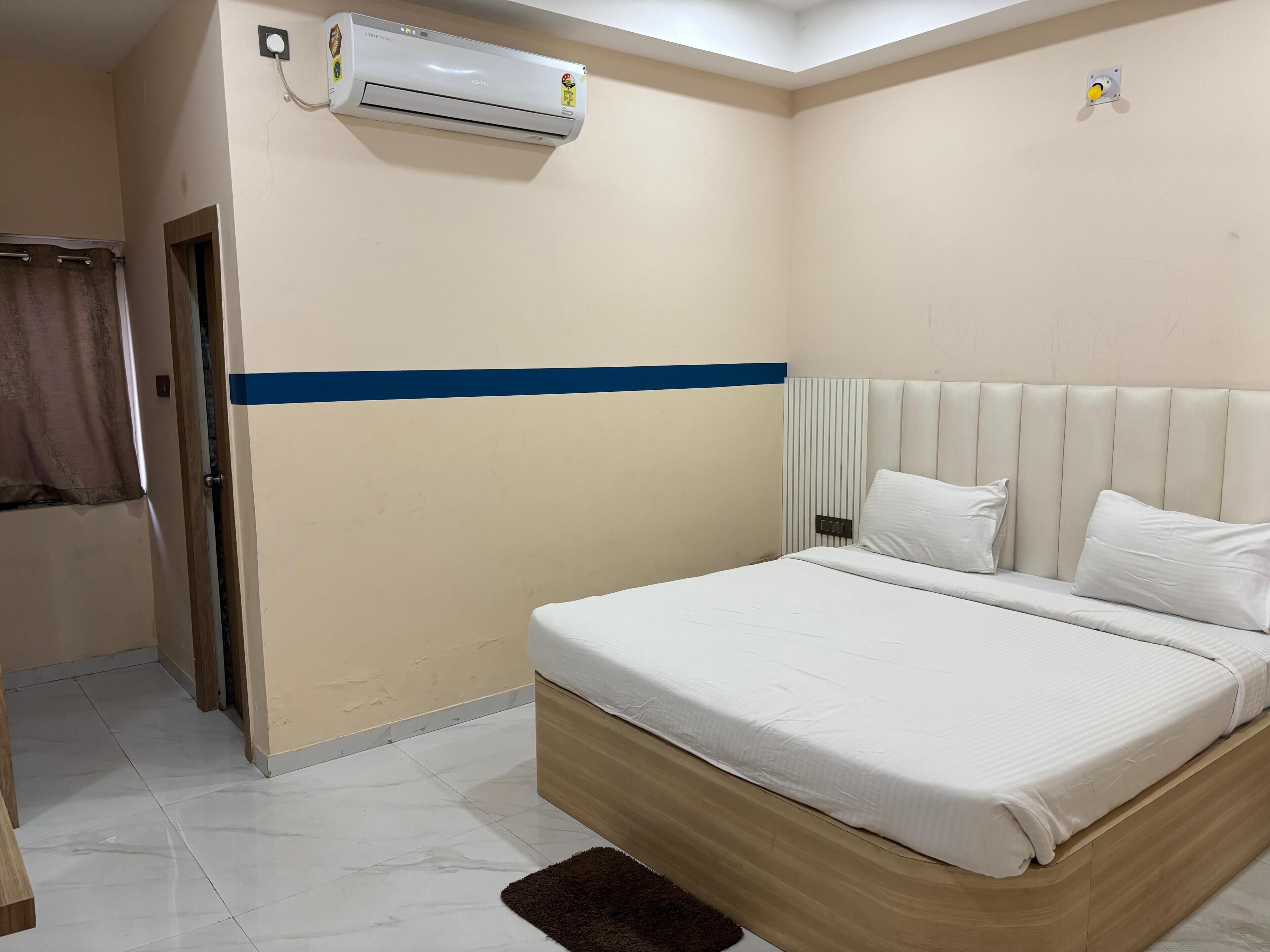 Una habitación de hotel con cama, baño y aire acondicionado.