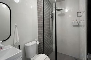 Un bagno moderno con il water, un lavandino e una doccia.