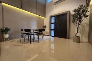 Un interno moderno con zona pranzo, una pianta in vaso e un'ampia porta.