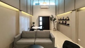A modern interior with a sofa, a dining table, and a potted plant. - Private & Cozy house, Chiang Rai Airport (Chiang Rai)