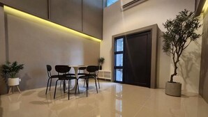 A modern lobby with a polished floor, a reception desk, and a potted plant. - Private & Cozy house, Chiang Rai Airport (Chiang Rai)