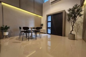 Un vestíbulo moderno con piso pulido, mostrador de recepción y una planta en maceta.