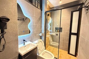 A modern bathroom with a glass-enclosed shower, a toilet, and a sink. - Galaria3 18PAX 4BRNearTC, DinosaurLand, PS4, Netfx (Kuala Kuantan)