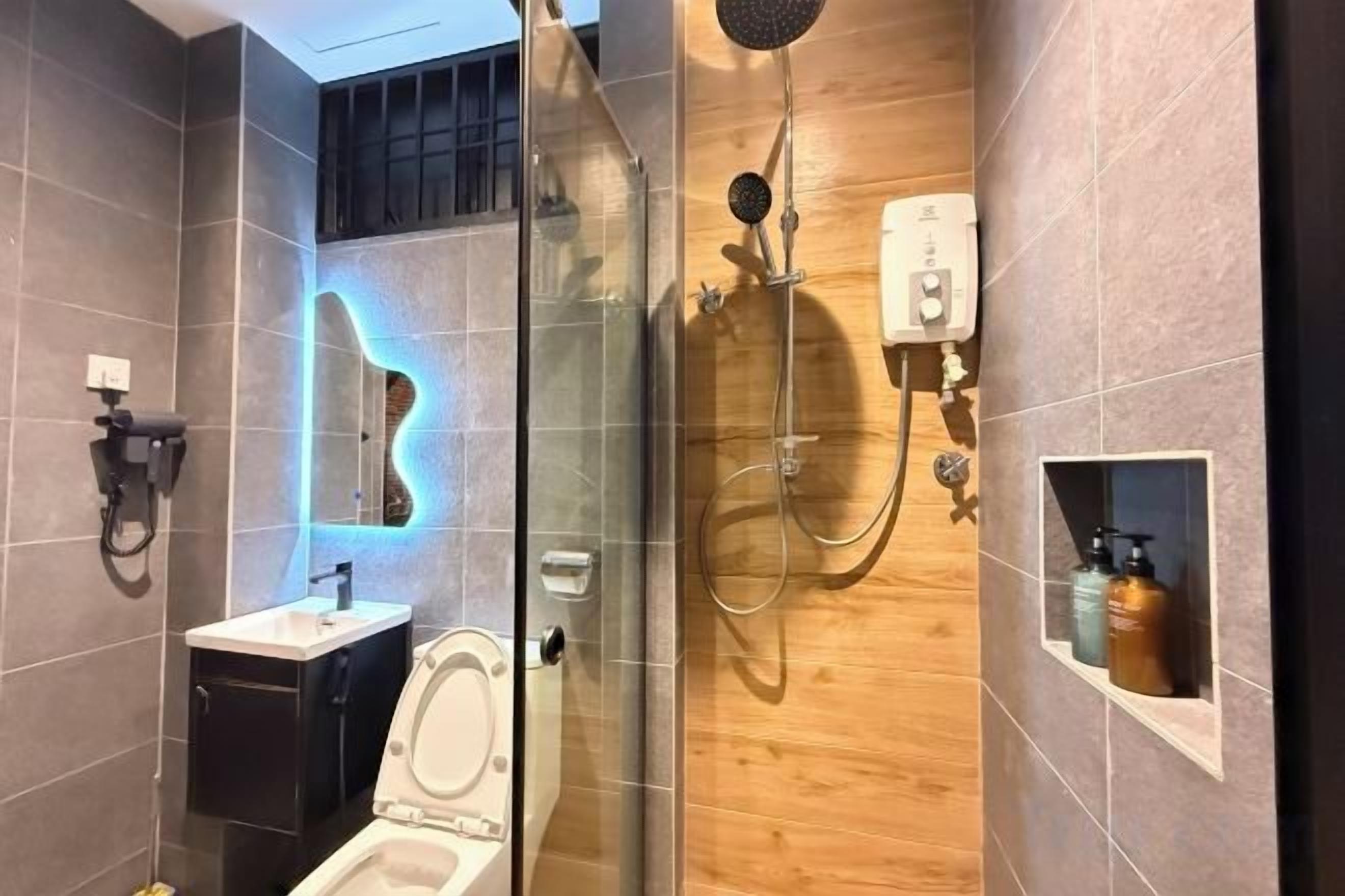 Un bany modern amb dutxa envidriada, un lavabo i un vàter.