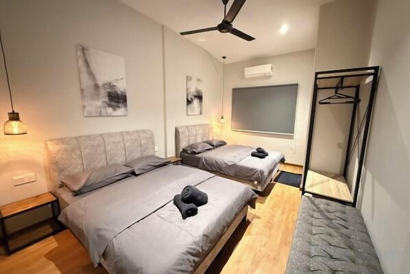 Un dormitorio moderno con dos camas, un ventilador de techo y un ventanal grande.