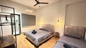 Ein modernes Schlafzimmer mit zwei Betten, einem Deckenventilator und einer Pendelleuchte.