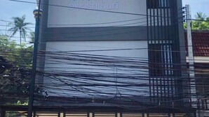 A building with a sign that reads "awashniun" in blue text. - Mildmint Self Serviced (Phuket)