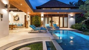 A modern house with a swimming pool, lounge chairs, and a dining area. - Villa Liang Ubud (Bali)