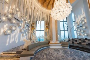 A luxurious interior with a grand chandelier, a curved seating area, and a patterned carpet. - Arte Cheras by KL Innfinity Stay (Kuala Lumpur)