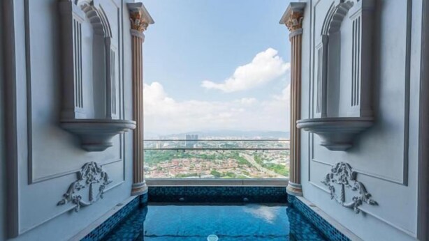 A view from a balcony with a pool, overlooking a cityscape. - Arte Cheras by KL Innfinity Stay (Kuala Lumpur)