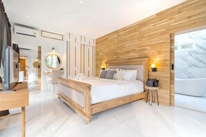 A modern bedroom with a wooden headboard, a bedside table, a large bed, a round mirror, and a view of a spa area. - 9 bedroom Stylish 2-Villa Combination by Hi At Home (Pattaya)