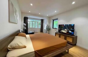 A hotel room with a bed, a TV, a desk, and a window. - OH Trendy homes Hoan Kiem LTK Bancony City view (Hanoi)