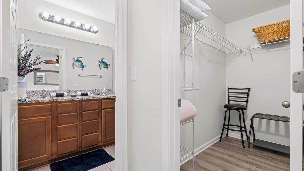 A bathroom with a shower, a towel rack, a stool, and a radiator.