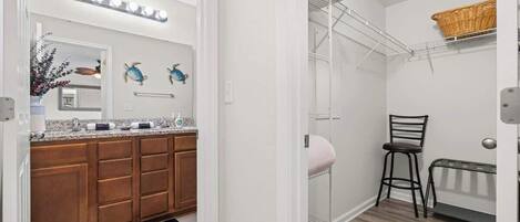 A bathroom with a shower, a towel rack, a stool, and a radiator.