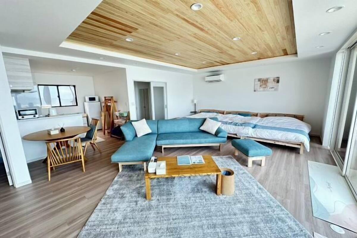 Ein modernes Wohnzimmer mit einem Ecksofa, einem Holztisch und einem grauen Teppich.