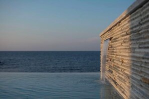 A poolside view with a stone wall and a clear view of the ocean. - Lapita Resort (Sakai)