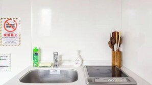 A kitchen with a stainless steel sink, a digital scale, and a wooden utensil holder. - Arai 1chome (Tokyo)