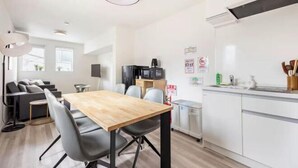 A modern apartment with a dining area, kitchenette, and a sofa set. - Arai 1chome (Tokyo)