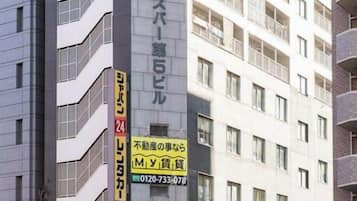 Un edificio de varios pisos con fachada comercial en la planta baja, que incluye una farmacia y un restaurante.