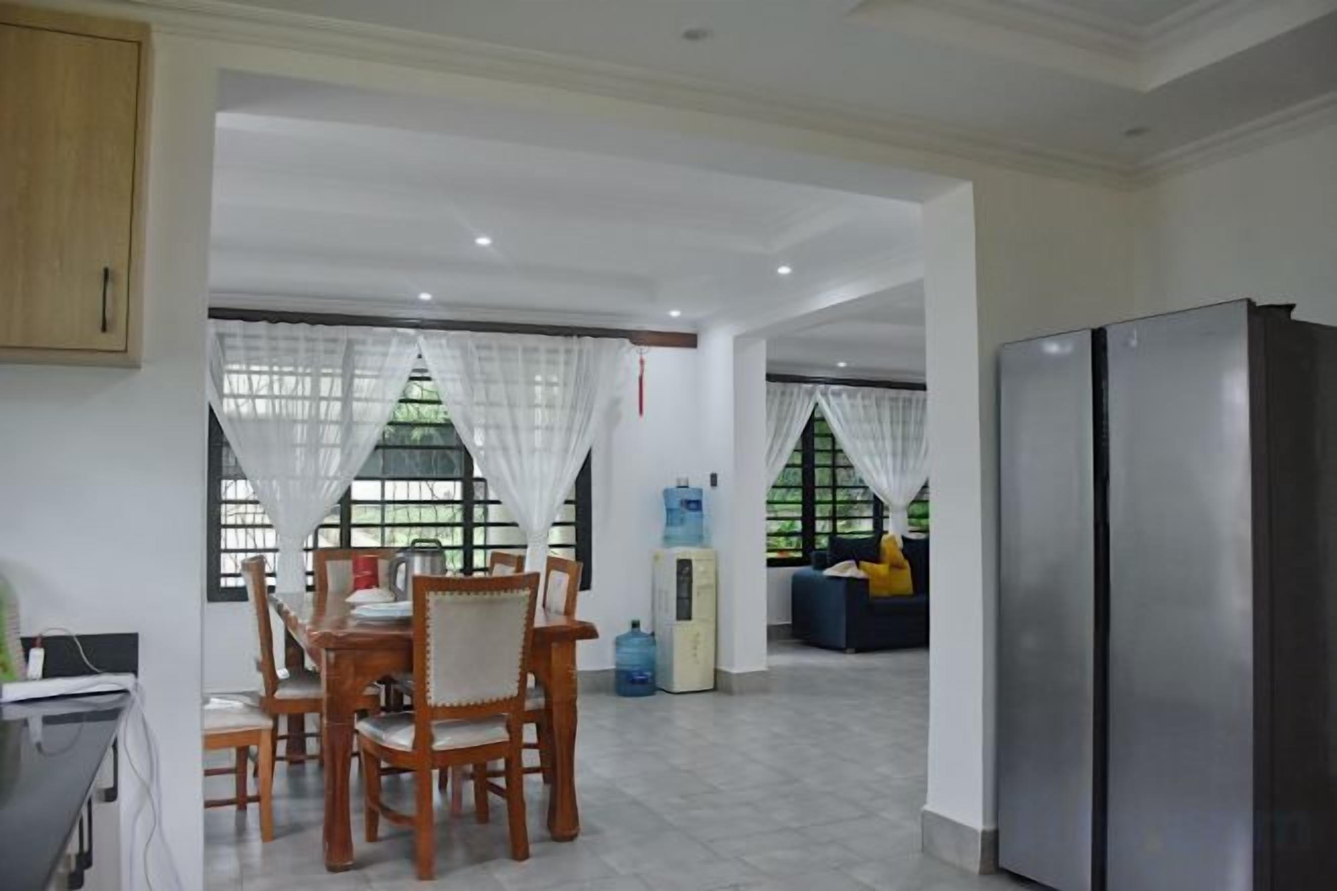 Una cocina amplia con comedor, refrigerador y dispensador de agua.