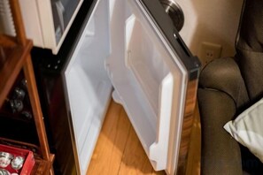 A kitchen with a white refrigerator, a wooden floor, and a brown sofa. - Tokyo Dome City Amusement Park Homestay (Tokyo)