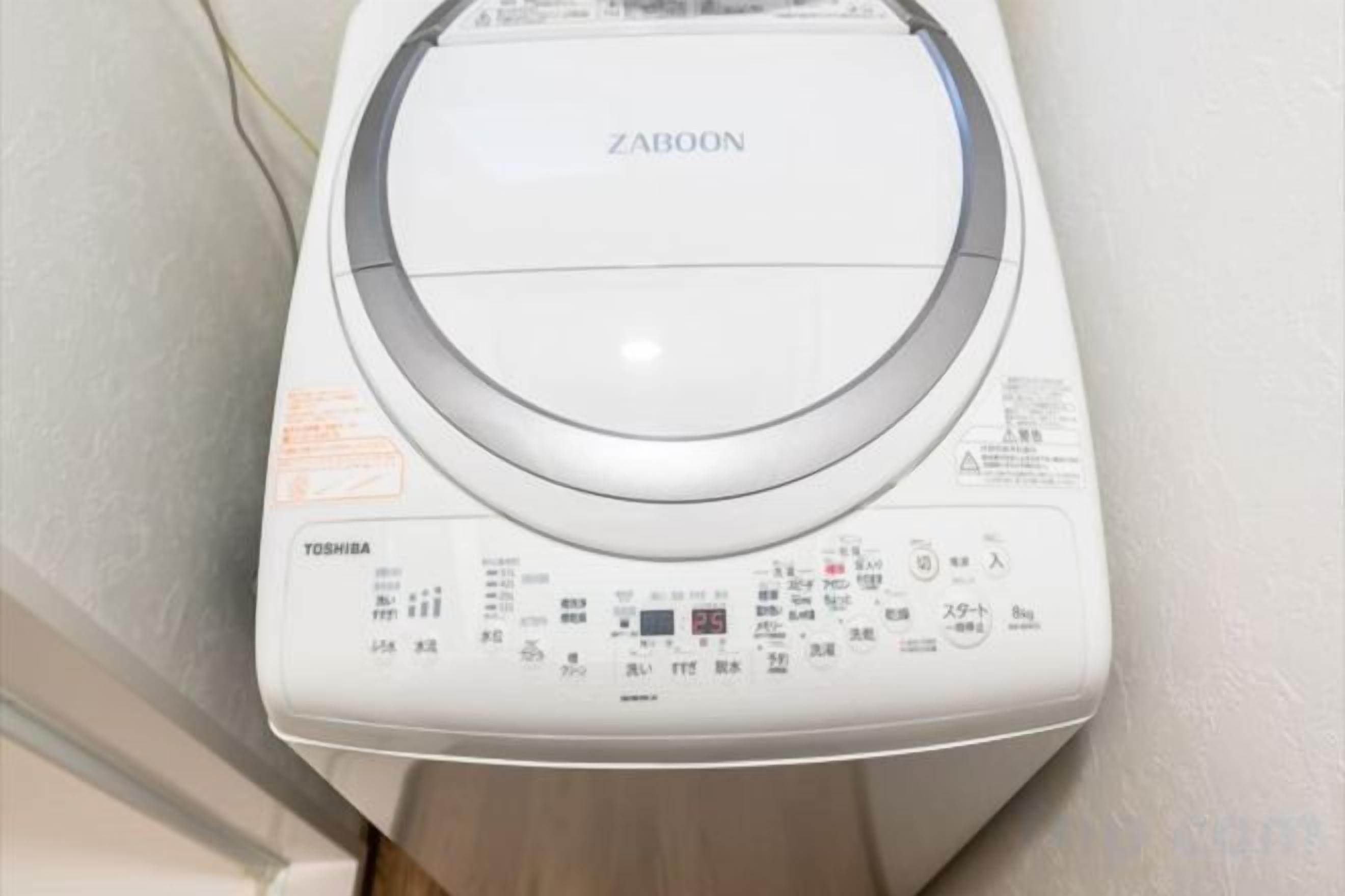 A white washing machine with a control panel, brand name 'ZABOON,' and 'TOSHIBA' label.