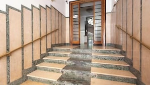 A staircase with alternating marble and wood steps, leading to a door with a glass panel.