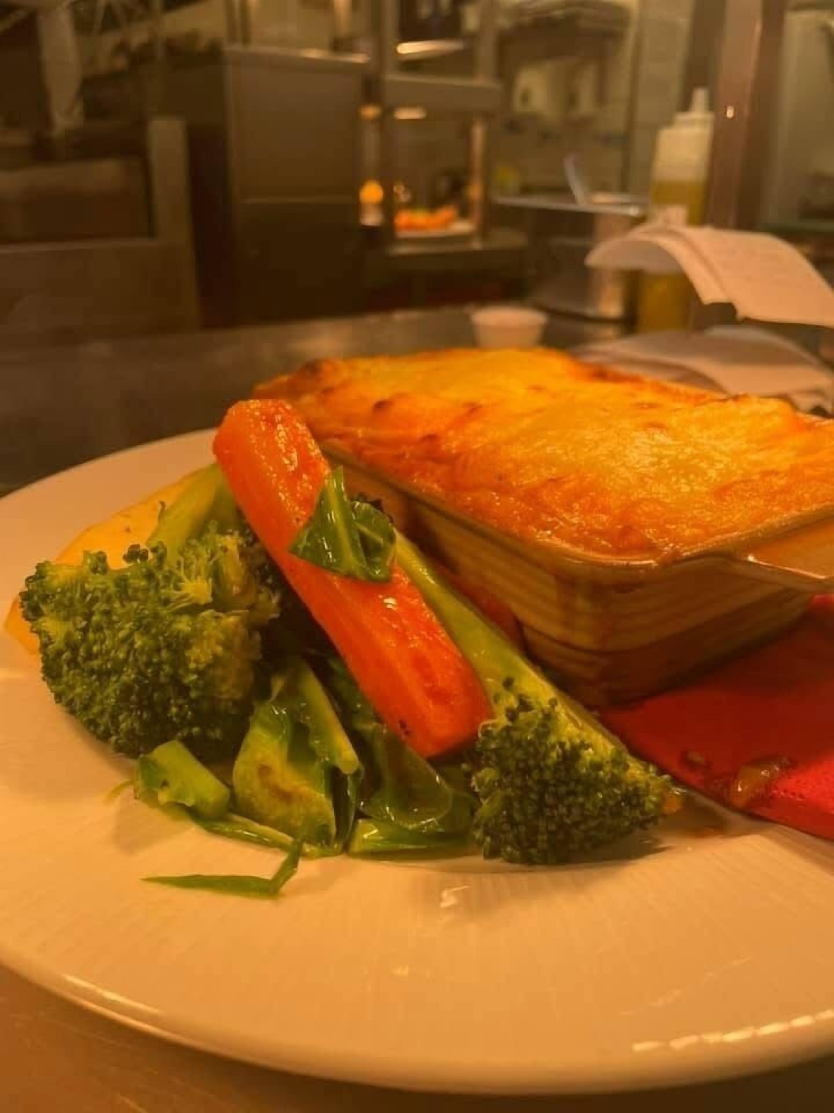 A plate with a baked dish and steamed vegetables.